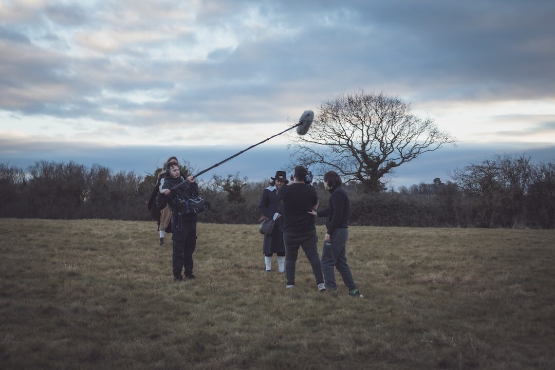 Behind the scenes view of a television crew filming with a boom microphone